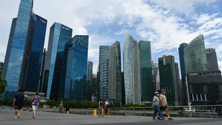People walk along the promenade at Marina Bay in Singapore on August 24, 2022. (Photo by Roslan RAHMAN / AFP) (Photo by ROSLAN RAHMAN/AFP via Getty Images)