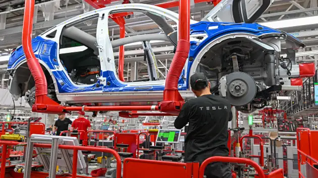 An employee of the Tesla Gigafactory Berlin Brandenburg works on a production line of a Model Y electric vehicle.